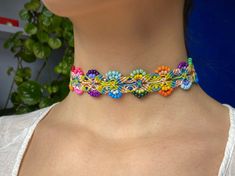 a woman wearing a multicolored beaded choker with flowers on the bottom