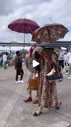 a man and woman dressed in animal print holding umbrellas