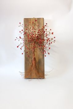 a piece of wood with red berries on it and roots sticking out of the top