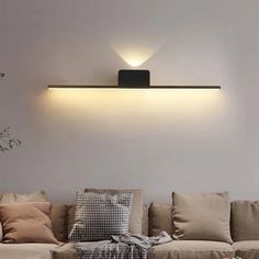 a living room filled with lots of furniture next to a wall mounted light above the couch