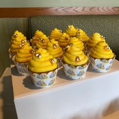 there are many cupcakes with yellow frosting on them