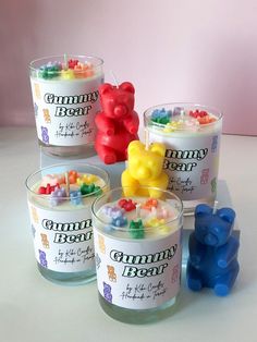 four jars of gummy bear ice cream on a white table with bears in them