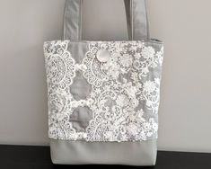 a gray and white lace bag hanging on a wall