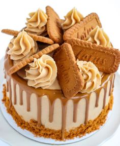 a close up of a cake on a plate with icing and cookies around it