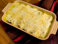 a casserole dish with cheese and broccoli in it on a table