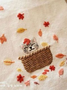 a close up of a piece of cloth with a cat in a basket on it