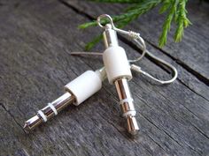 a pair of white ear buds sitting on top of a wooden table next to a plant