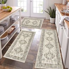 three rugs in the middle of a kitchen with fruit on the counter and plates