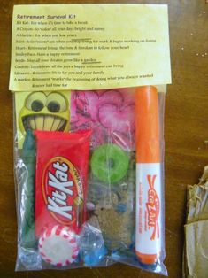 an assortment of candy and candies in a plastic bag on a wooden table top