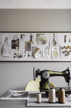 a sewing machine sitting on top of a table next to spools of thread