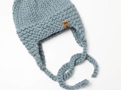 a blue knitted hat with a knot around the brim on a white background