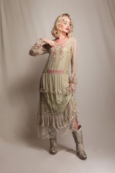 a woman in a dress and cowboy boots posing for the camera