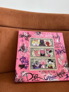 a pink piece of paper with various stickers on it sitting on top of a couch