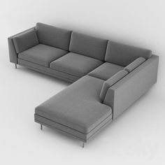 a gray sectional couch sitting on top of a white floor