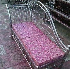 a metal bench with a pink cushion on it