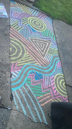 the sidewalk is painted with colored chalks and has an interesting design on it's side