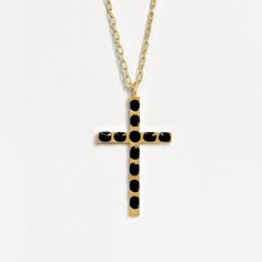 A close up of a gold cross pendant with black enamel circles, shown over a gray background. Black Enamel Jewelry As Gift, Black Enamel Jewelry For Gift, Black Enamel Jewelry For Gifts, Onyx Long Necklace Jewelry Gift, Onyx Cross Jewelry As A Gift, Black Jewelry With Adjustable Chain And Cross Pendant, Onyx Necklace With Adjustable Chain For Gifts, Onyx Jewelry With Black Enamel For Gifts, Black And Gold Cross Necklace