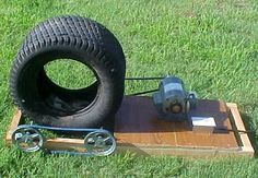 an old tire sitting on top of a piece of wood in the middle of some grass