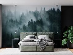 a bedroom with a forest mural on the wall and a bed in front of it