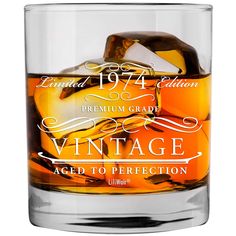 an old fashioned whiskey glass with ice cubes in it and the words vintage aged to perfection