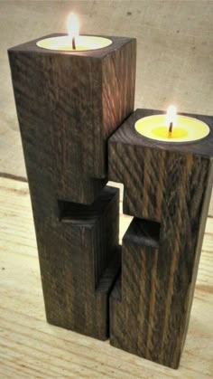 three wooden candles are stacked on top of each other in the shape of blocks with one candle lit