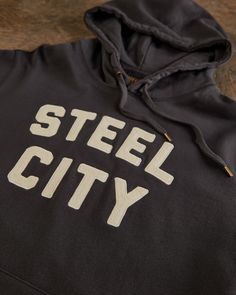 Our Vintage Stitched Logo Pullover is crafted with luxurious comfort in mind. Made from a mid-weight 400 gram 100% cotton that's pre-shrunk for the perfect fit. Garment dyed and washed for a soft finish, featuring our embroidered Steel City Logo. You'll never want to take it off on those late nights and chilly mornings. Perfect for summer adventures. Urban Black Logo Sweatshirt, 10 Logo, Logo Mugs, City Logo, Strapback Hats, Steel City, For Sale Sign, Summer Adventures, Shirt Shop