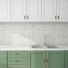 a kitchen with green cabinets and a white counter top that has a sink in it