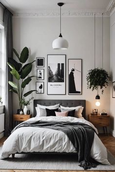 a bedroom with white walls and pictures on the wall above the bed, along with plants