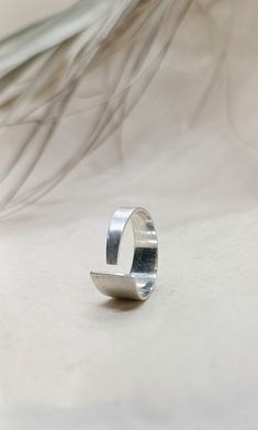 Crafted for elegance and simplicity, this Sleek Sterling Silver Open Band Ring showcases a Contemporary Matte Finish, embodying adjustable minimalism at its finest.  The open band design provides a custom fit for any wearer, while its sterling silver composition ensures lasting shine and durability.  Perfect for those who appreciate modern, understated jewelry, this ring comes in a branded organic cotton pouch, ideal for gifting or as a timeless addition to your collection. To find your size, measure the inner diameter of another (completely round) ring and compare it with the last image (column 3). To be sure, measure your finger with a paper measuring tape and check if it matches the same size (column 2). If you need a size that isn't listed, feel free to reach out to me. Request the Ame Understated Jewelry, Cotton Pouch, Band Design, Contemporary Ring, Round Rings, Cute Rings, Design Jewelry, Measuring Tape, Recycled Metal