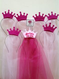 three princess dresses with pink crowns on them are displayed in front of a white wall