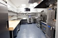 a commercial kitchen with stainless steel appliances and counters in the center, including two ovens