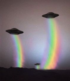 three flying saucers in the sky with a rainbow colored light coming from one side