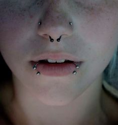 a woman with piercings on her nose looking at the camera