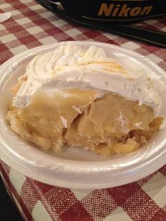 a piece of pie sitting on top of a white plate covered in frosting and whipped cream