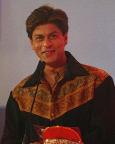 a man standing at a podium holding an award