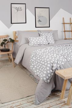 a bed sitting in a bedroom next to two pictures on the wall with ladders