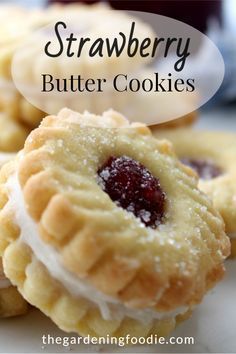 strawberry butter cookies with white icing and jelly on top, sitting on a plate