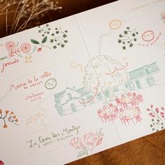 a close up of a piece of paper with drawings on it and flowers in the background