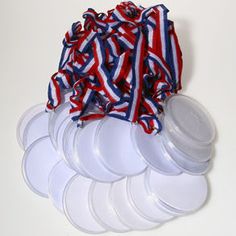 white plates with red, white and blue ribbons on them are stacked next to each other