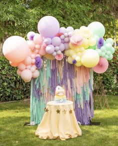 a table topped with balloons and a cake