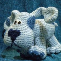 a crocheted stuffed dog sitting on top of a blue blanket