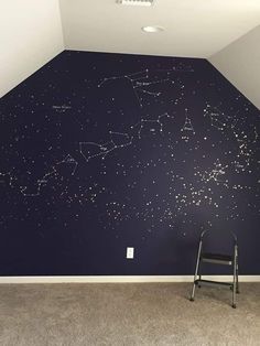 an empty room with a ladder in front of the wall and stars on the ceiling