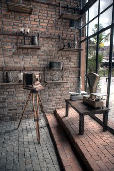 a room with brick walls and flooring is shown in the foreground, there are several shelves on either side of the wall