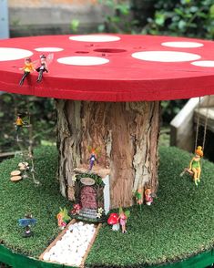 a table made out of a tree stump with little fairy figurines on it