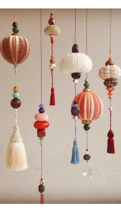 a group of different types of ornaments hanging from the ceiling with tassels and beads