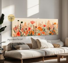 a living room scene with focus on the couch and flowers painted on the wall above it