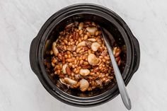 the food in the slow cooker is ready to be eaten and served with a spoon