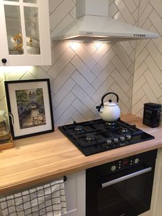 a stove top oven sitting inside of a kitchen next to a wall mounted range hood