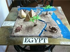 an egyptian themed table with paper mache animals and pyramids on it, along with a sign that says egypt