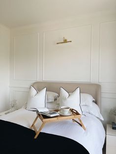 a bed with white sheets and black pillows